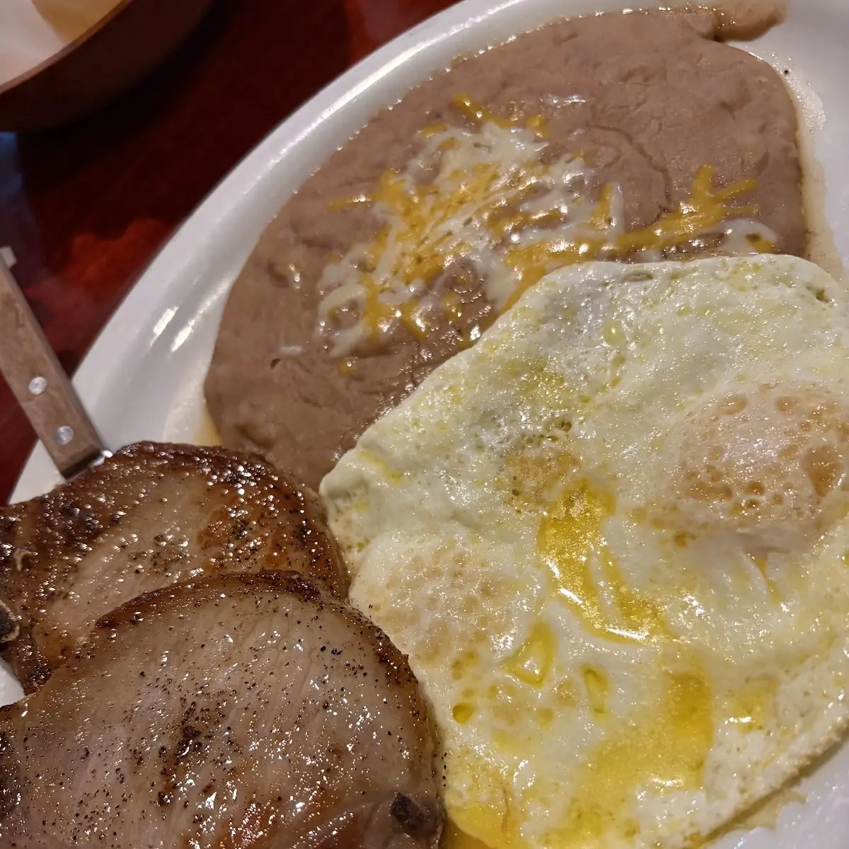 Two Enchiladas with Two Eggs on Top Served with Beans
