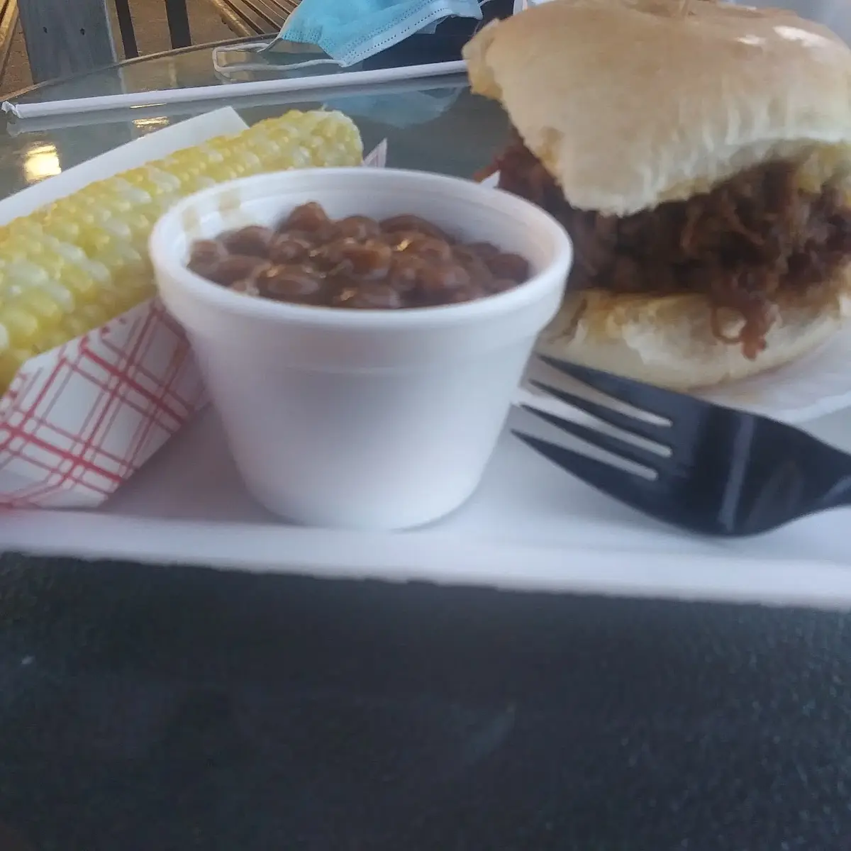 Pulled Pork Sandwich Jack Daniels Sauce Side of Corn on the Cob Side of Baked Beans