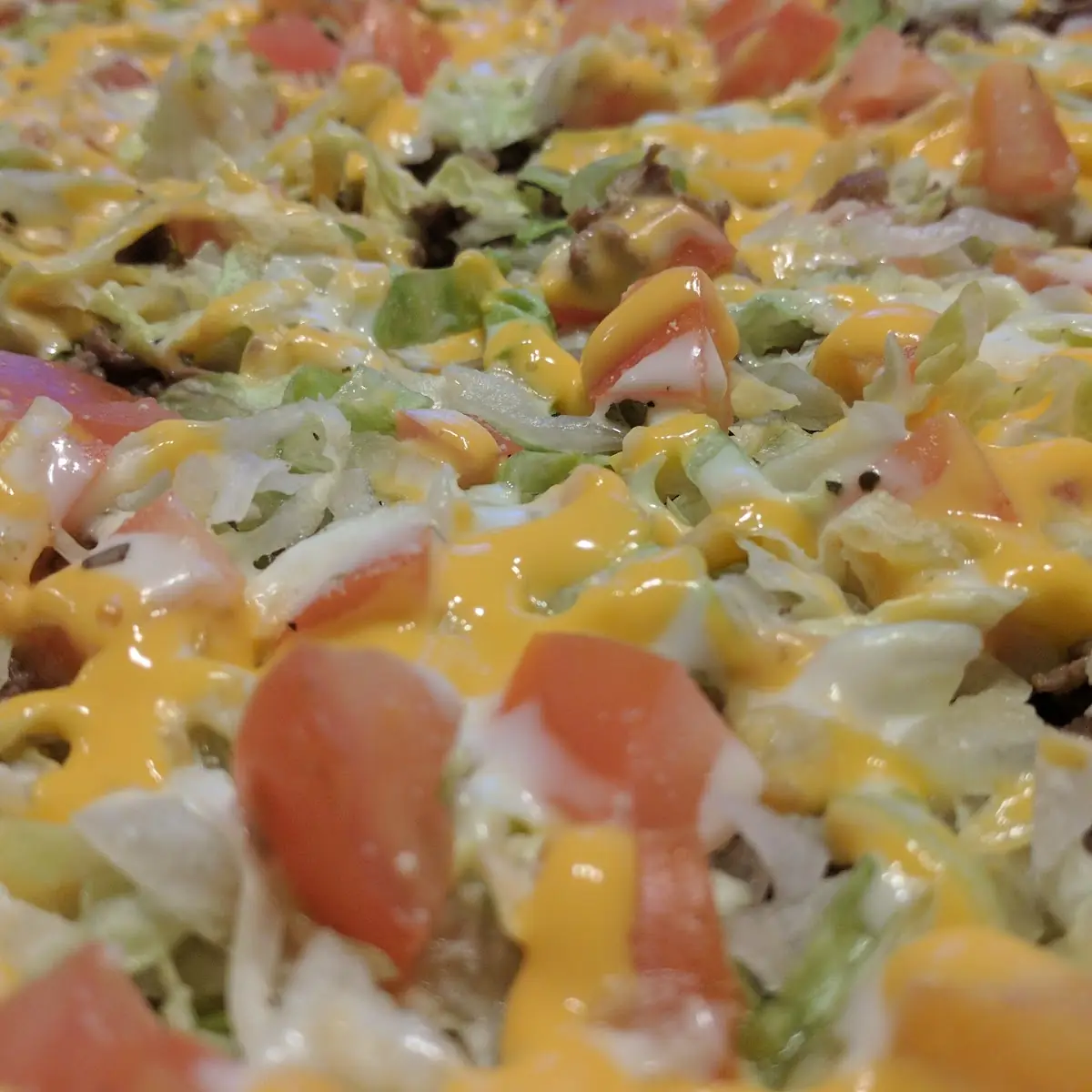 Taco Pizza with Steak Lettuce Tomatoes Onions Mozzarella Blue Cheese & Hot Sauce