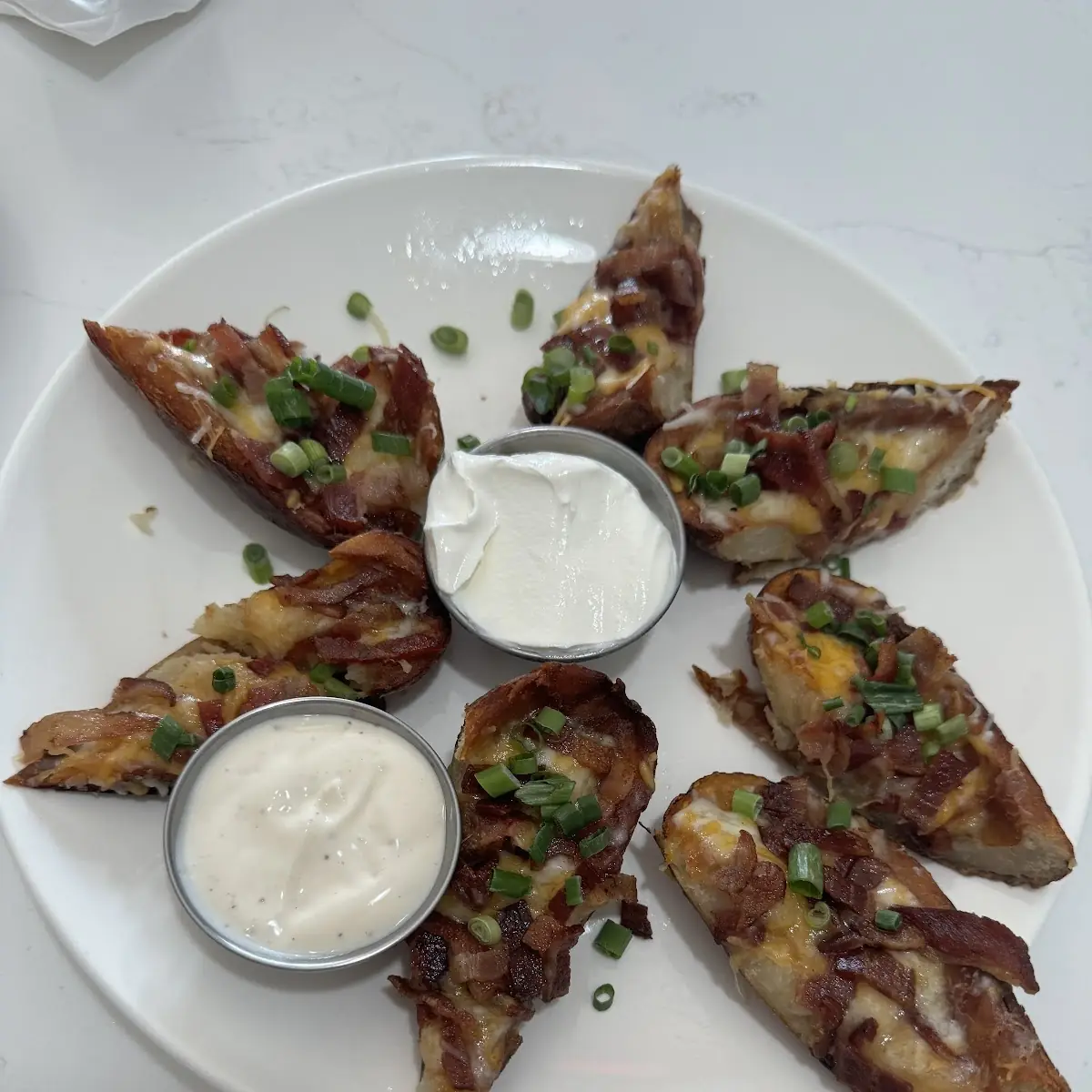 Potato Skins with Crispy Bacon Bits Cheddar Cheese Onions and Sour Cream