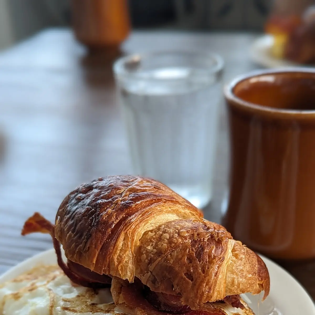 One Hander Scrambled Eggs with Bacon on a Croissant