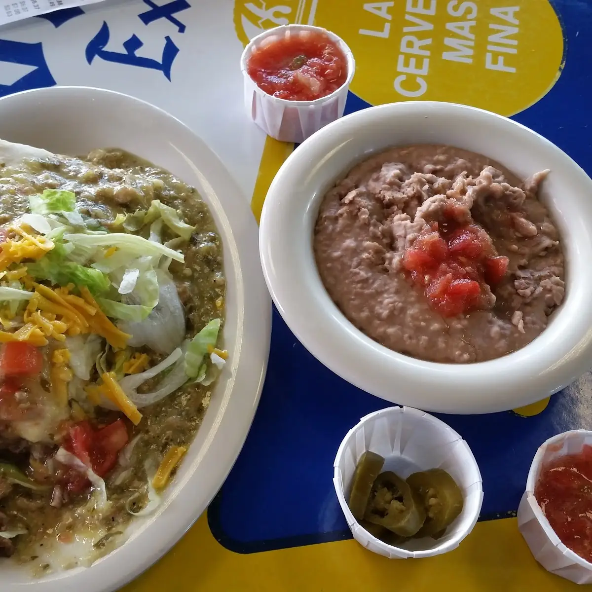 Bean and Beef Burrito Smothered with Green Chile Lettuce and Tomato Side of Refried Beans