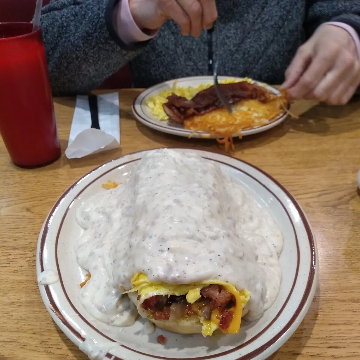 Bacon Sausage and Cheese Omelette on a Biscuit and Hash Browns Smothered in Sausage Gravy