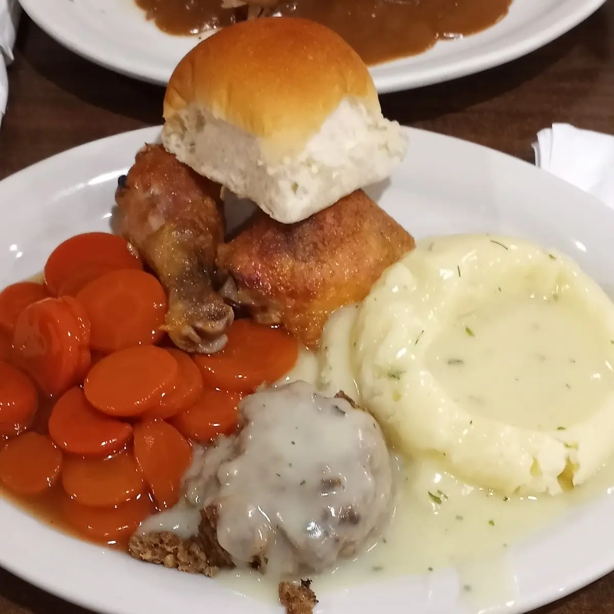 Baked Chicken Mashed Potatoes with Gravy Dressing with Gravy Glazed Carrots and a Bun