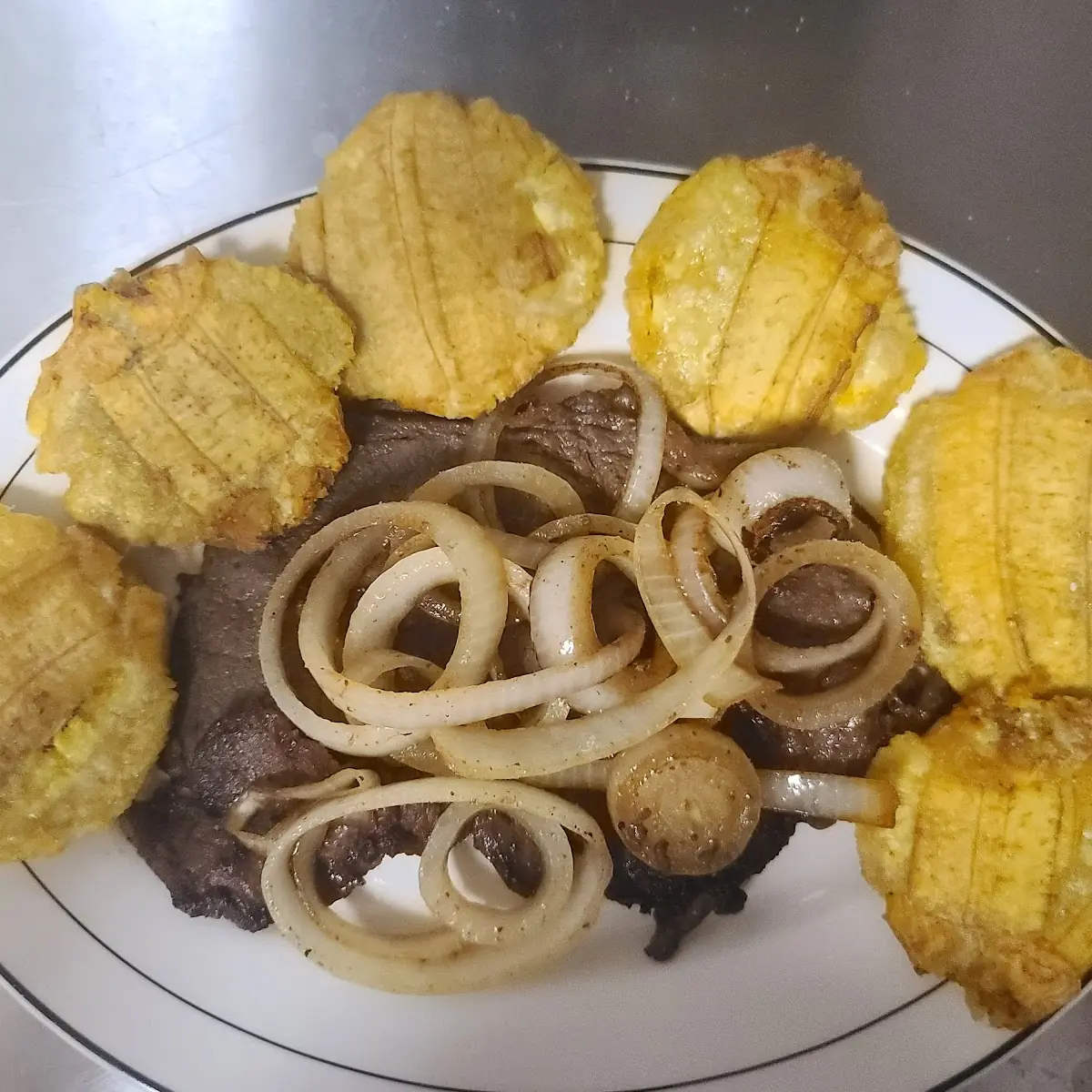 Carne Encebollada Con Tostones
