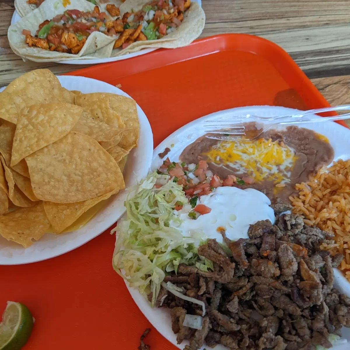 Sliced Steak Yellow Rice and Refried Beans Corn Chips on the Side