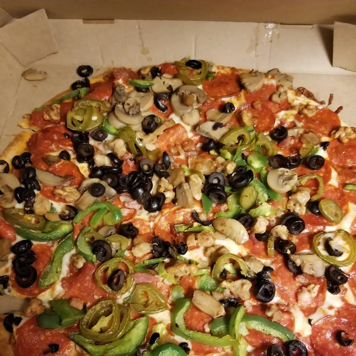 Thin Crust Pizza with Black Olives Bell Peppers Mushrooms Pepperoni Sausage Bacon Jalapenos