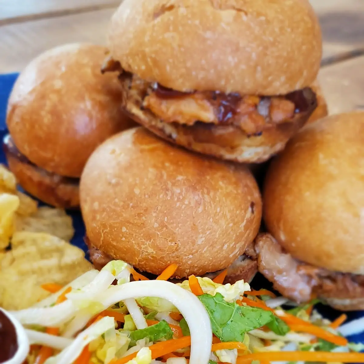 Sliders Baked Brioche Buns 18-Hour Slow-Cooked-Pulled-Pork Served with Slaw Kettle Chips and Pickles