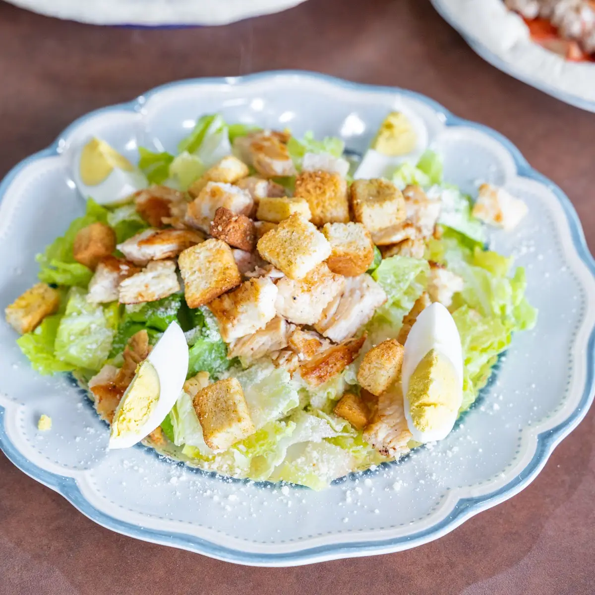 Caesar Salad with Romaine Lettuce Croutons Eggs and Parmesan Cheese Served with Garlic Bread