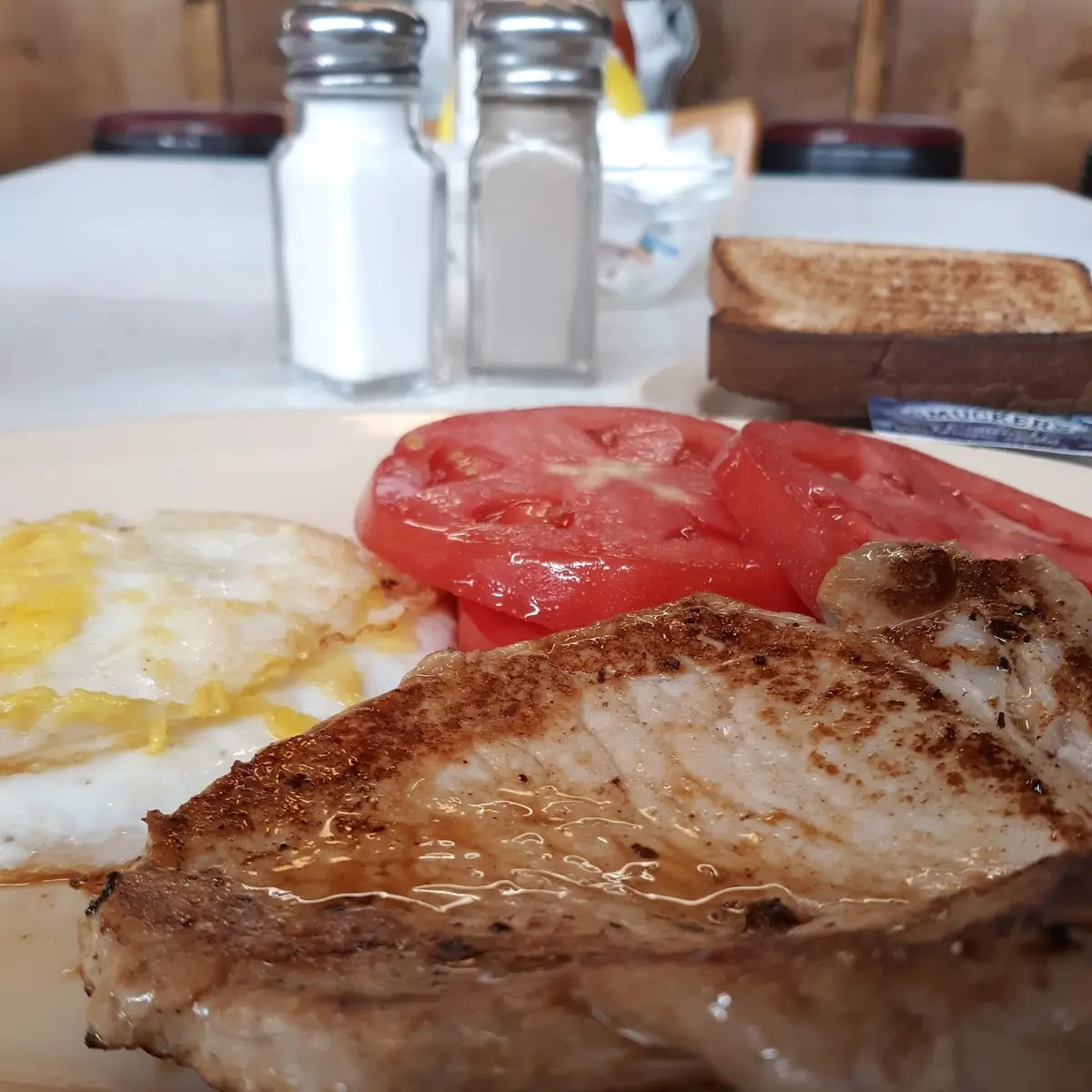Pork Loin with Fried Eggs and Sliced Tomatoes
