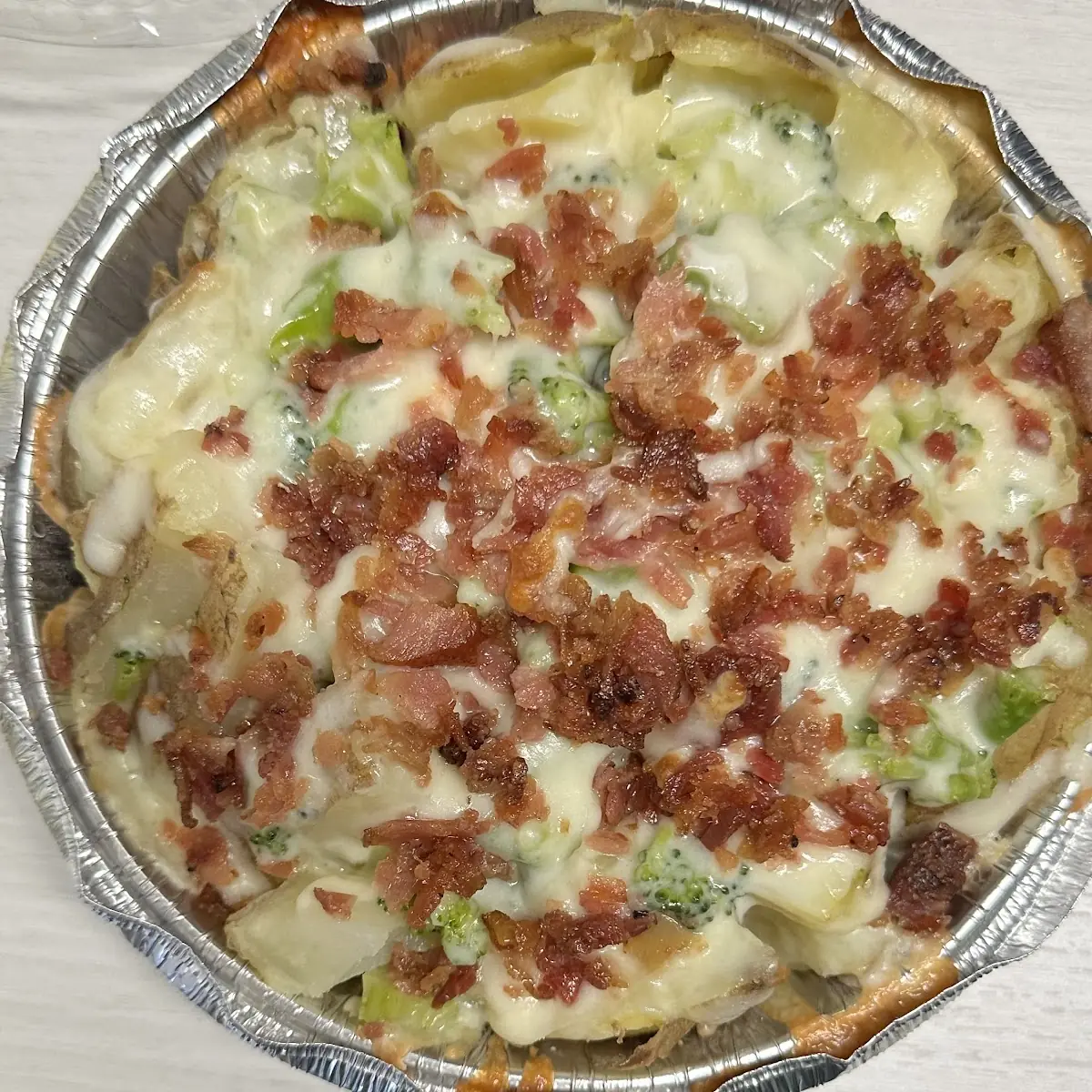 Baked Potato with Broccoli Mozzarella Cheese Bacon Bits Real Bacon and Sour Cream on the Side