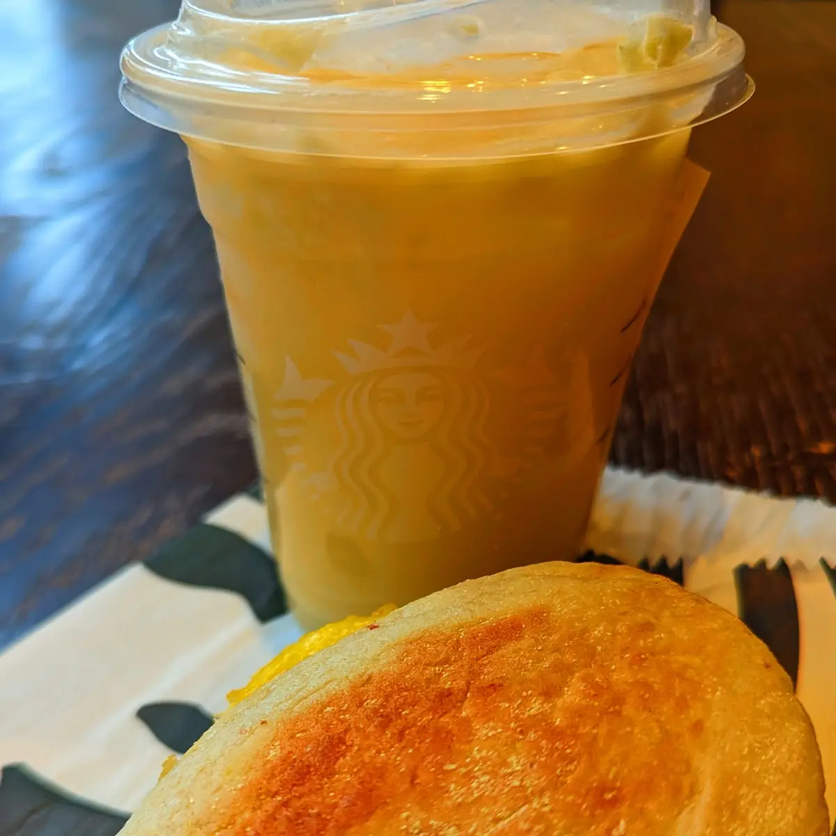Pineapple Starbucks Refreshers Beverage with Cheddar Sausage Egg & Cheese Breakfast Sandwich