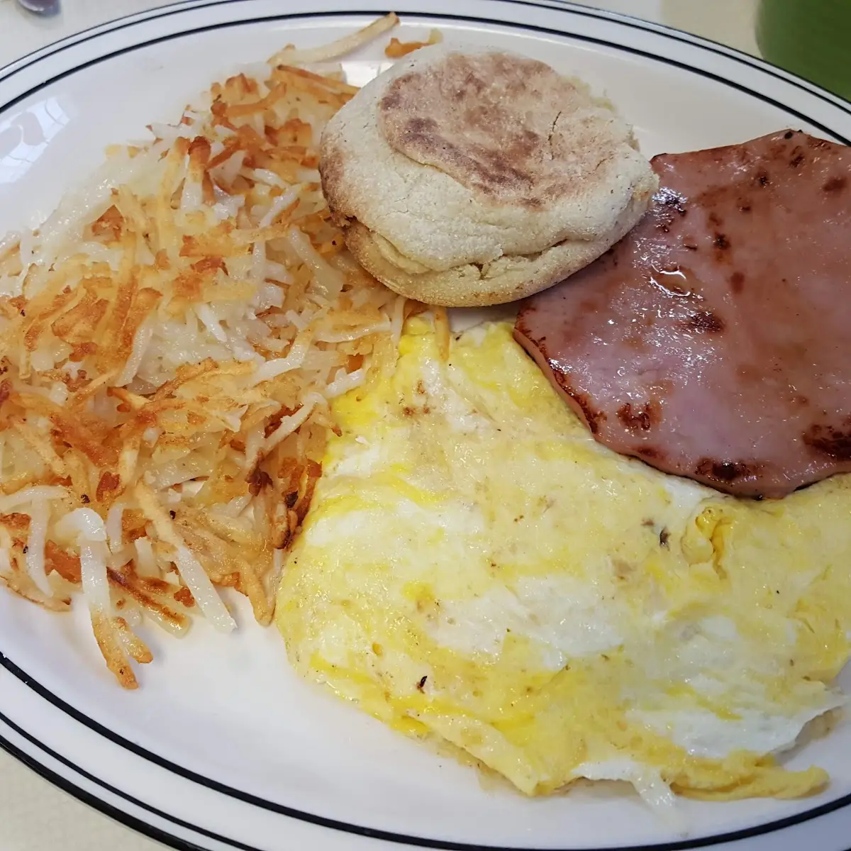 Big Breakfast with Eggs Ham Hash Browns and English Muffin