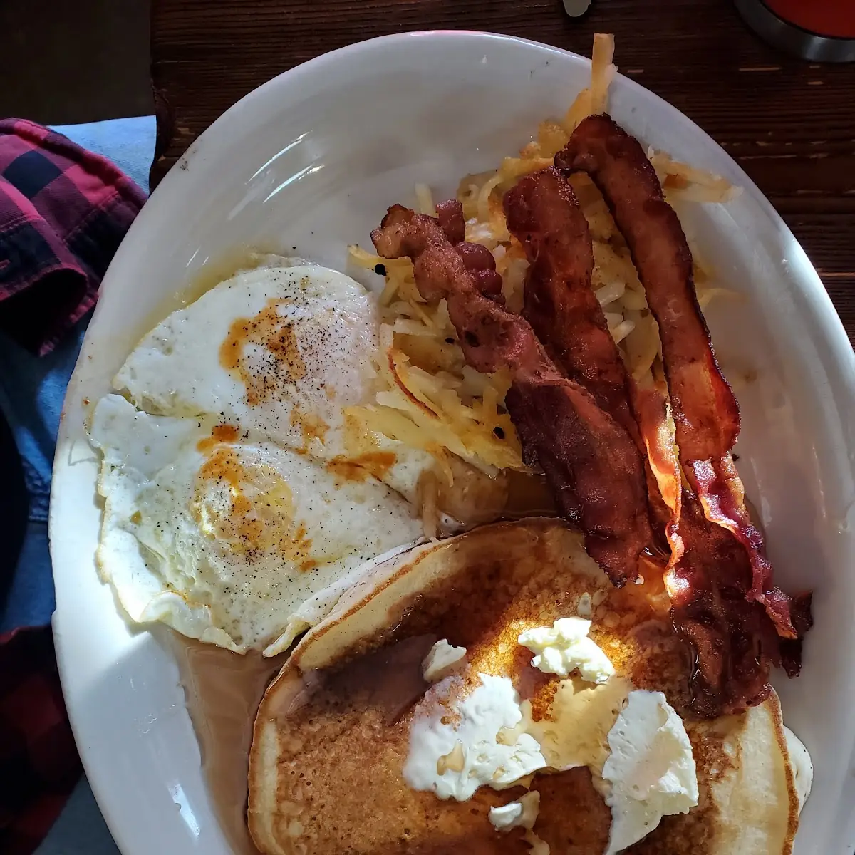Two Fried Eggs over Easy Bacon Hash Browns and a Pancake