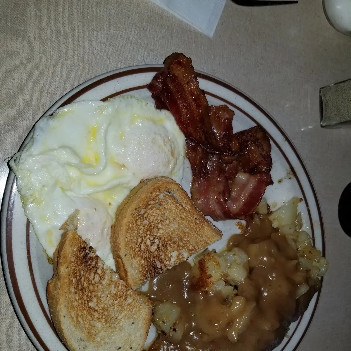 Eggs over Easy with Bacon and Gravey on Hash Browns
