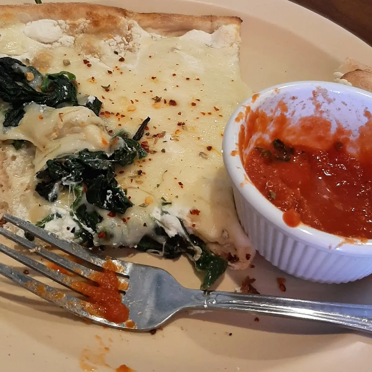 Slice of Spinach Ricotta and Mozzarella Pizza with a Side of Marinara Sauce