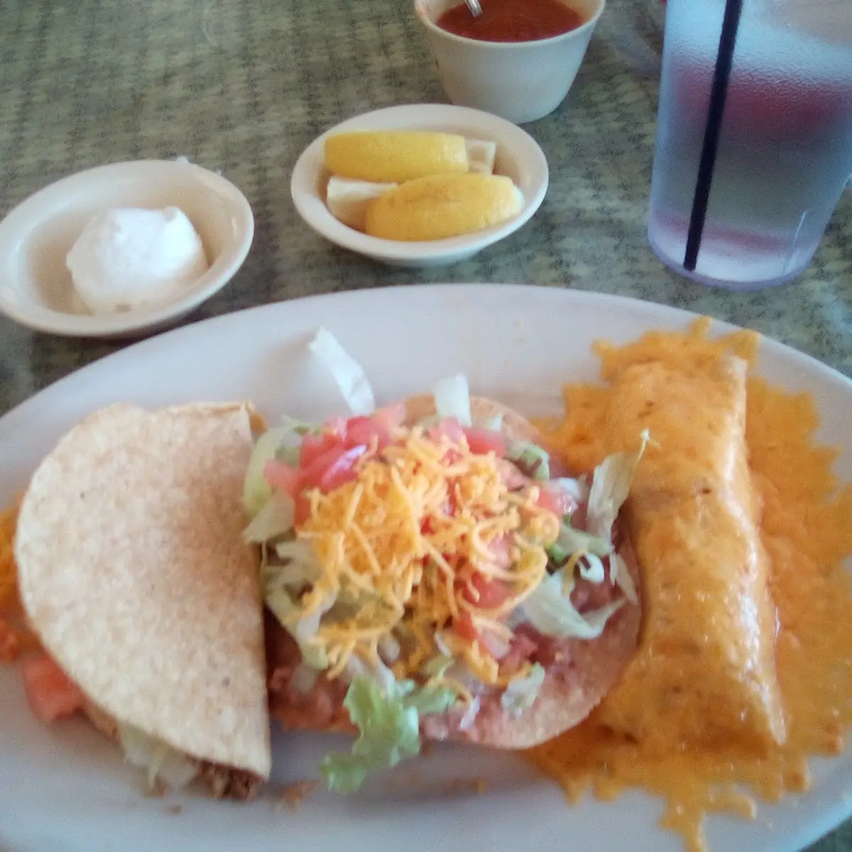 1 Beef Taco 1 Tostada Chicken Enchilada with Grated Cheese on Top and Sour Cream on the Side