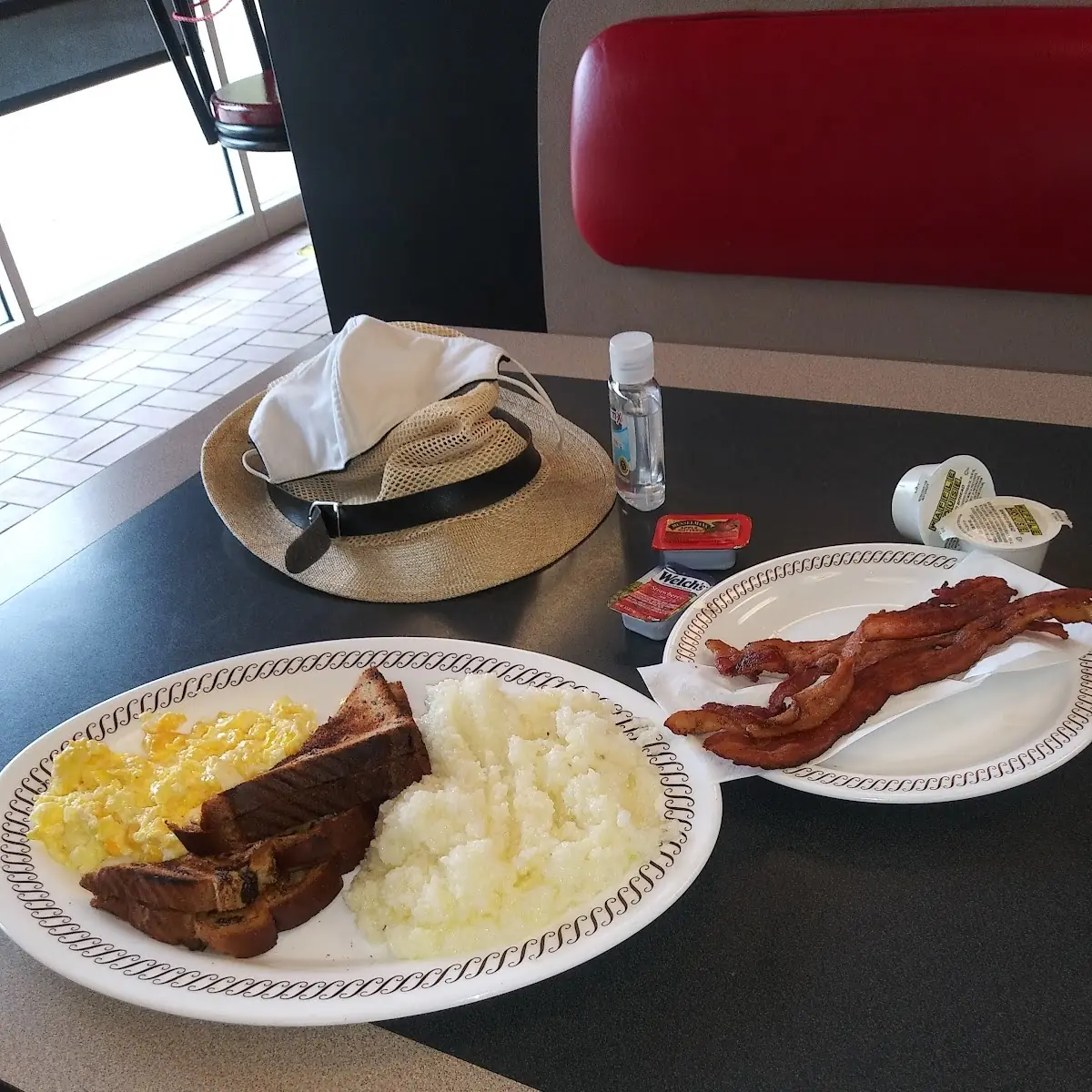 Scrambled Egg with Raisin Toast Crispy Bacon Grits and Water with a Side of Mask Hat and Sanitizer