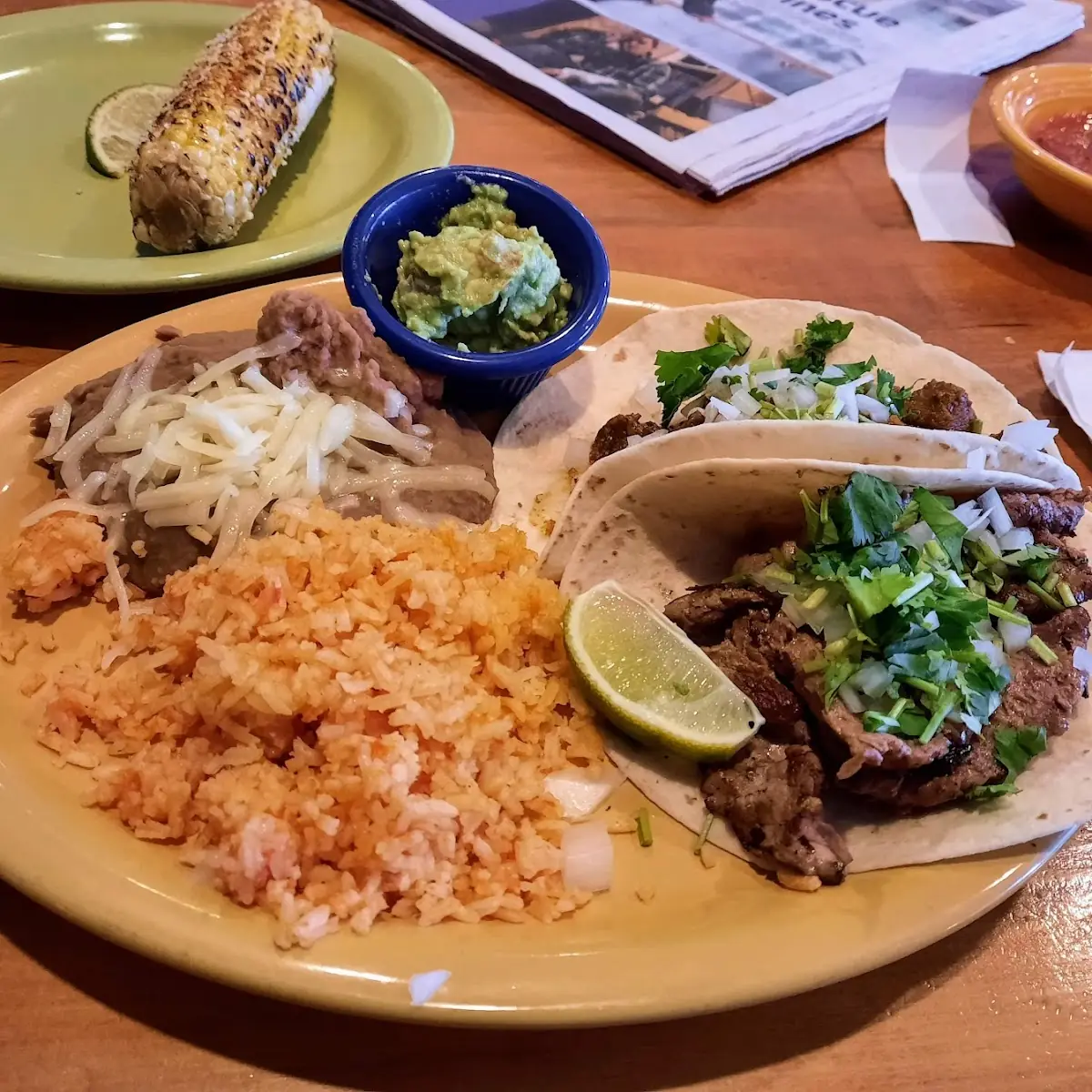 2 Taco Platter with Refried Beans and Rice Elote in the Background