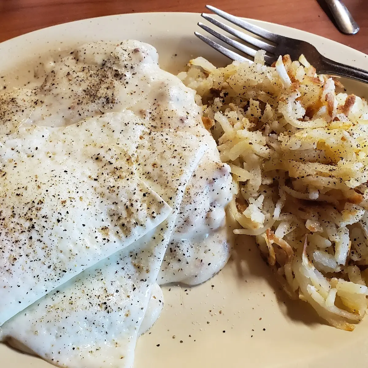Biscuit & Gravy with Two Eggs on Top and Hash Browns