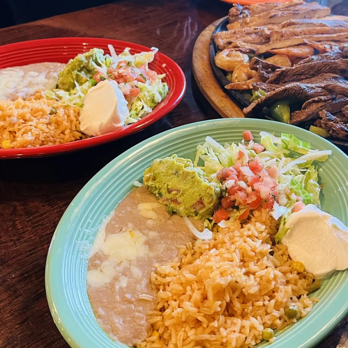 Foreground Chimichanga Enchilada Gordita Background Fish Tacos Both with Rice & Refried Beans