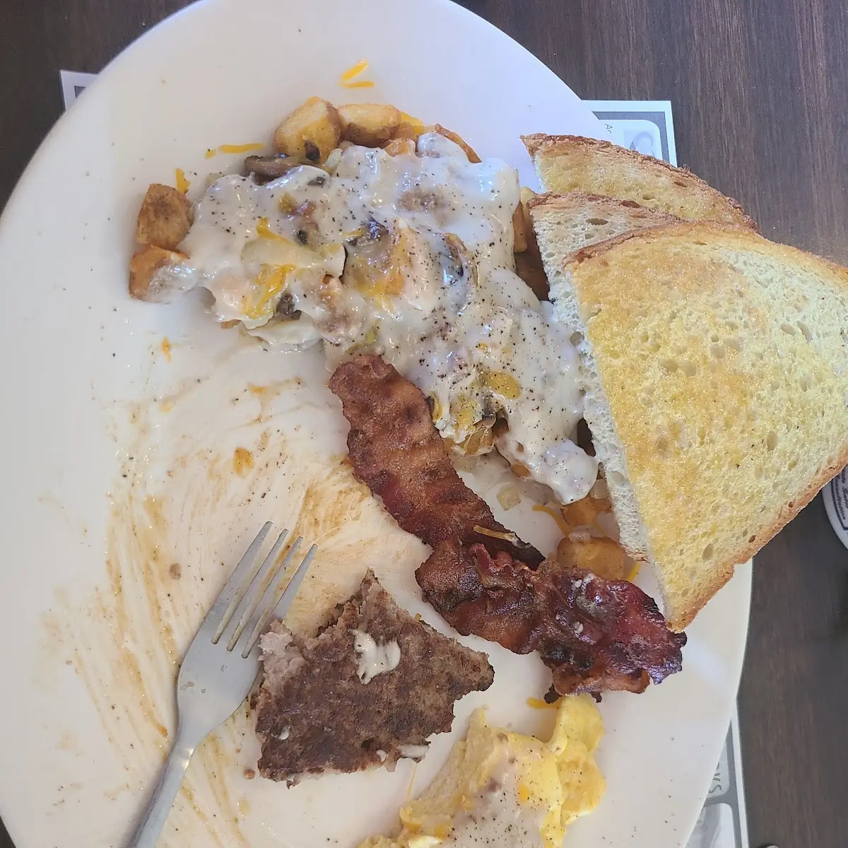 Scrambled Eggs Deep Fried Potatoes Mushrooms Onions Cheese Sausage Bacon and Gravy