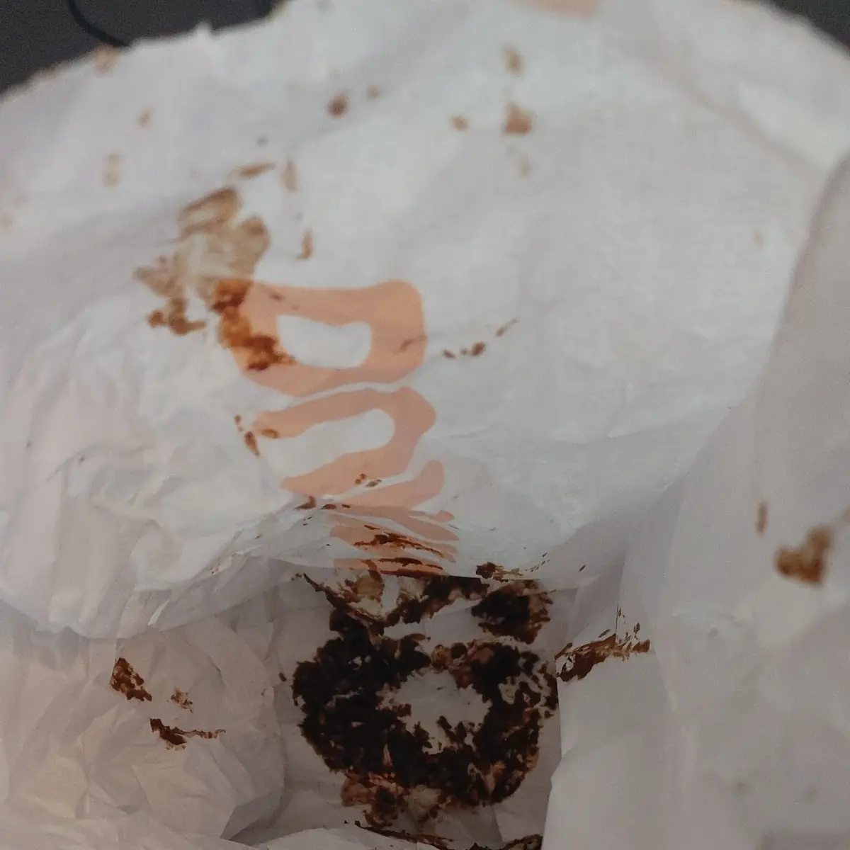 Chocolate Iced Sprinkle Donut Placed Upside Down in Bag
