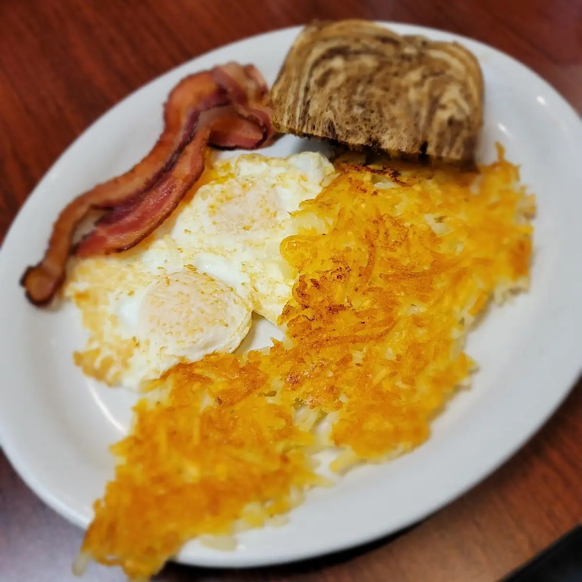 Over Easy Eggs Hash Browns Bacon and Toast