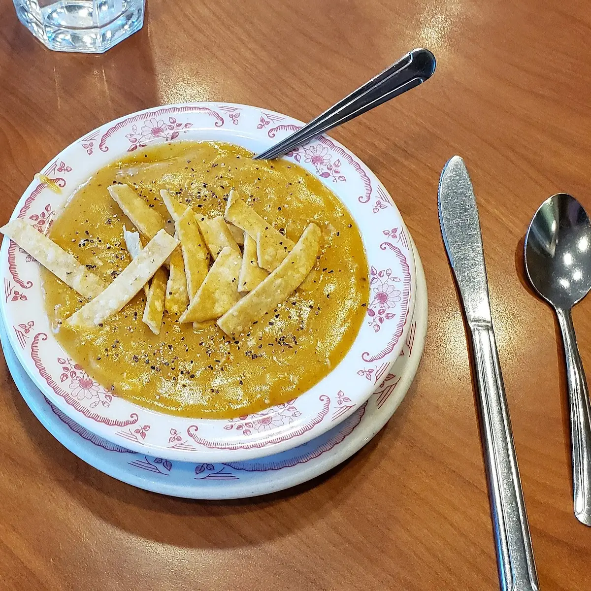 Chicken Enchilada Soup Topped with Tortilla Strips and Black Pepper