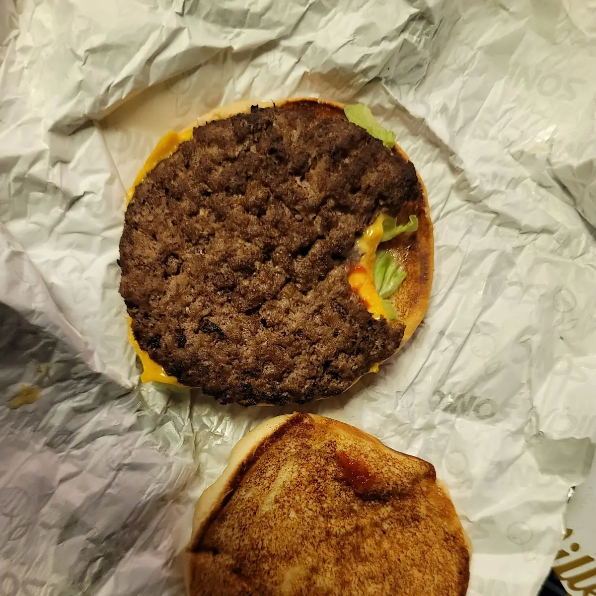 Sonic Cheeseburger Served with a Bite Taken