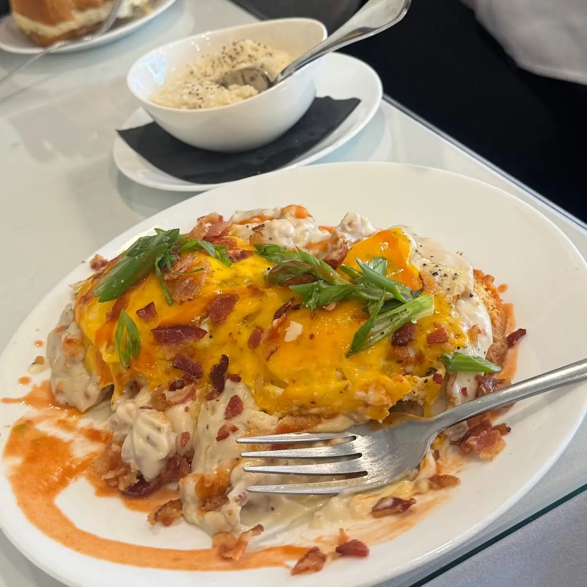 Loaded Biscuits and Gravy with Two Eggs Bacon Cheddar Green Onions and Hot Sauce
